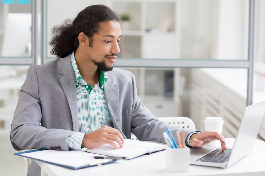 Man looking at his PC to see if he is qualified to start a credit repair business and help people with credit.