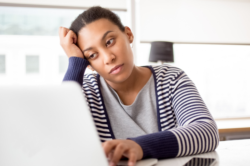 A lady stirring at a laptop and wondering if she is good enough to start a credit repair business