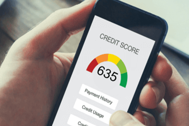 A hand holding a phone with a credit report having a bold 635 credit score