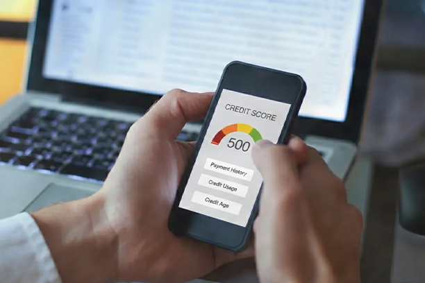A person checking their credit report with their phone and wondering "Can I Lease a Car with a 500 Credit Score?"