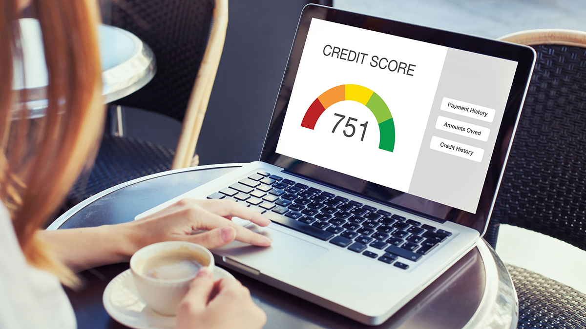 Lady sipping coffee and checking her credit score on her PC