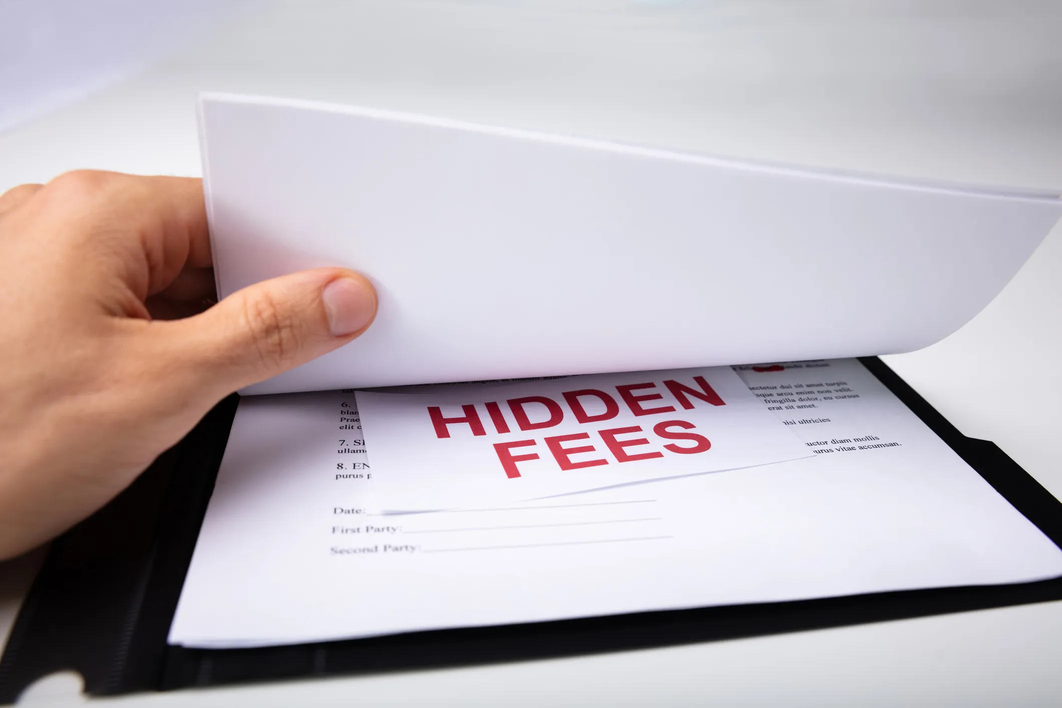 A document with slip labelled "HIDDEN FEES" in it's middle.