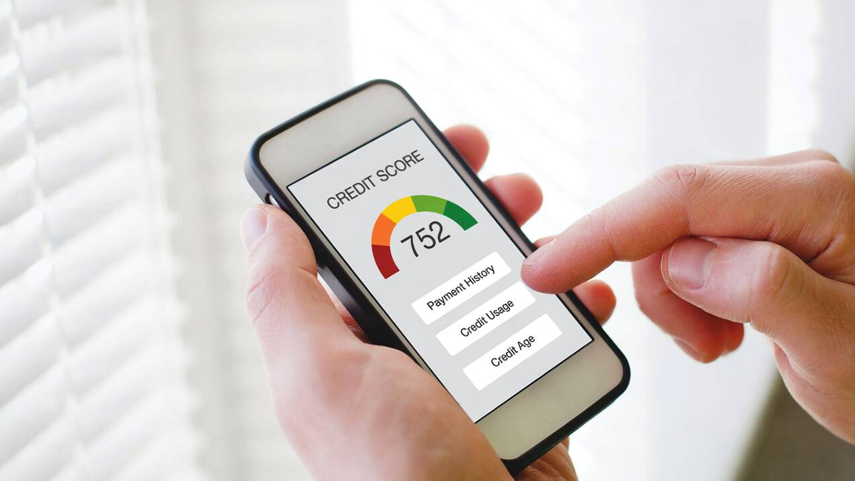 Human hand checking their high credit score resulting from low credit utilization